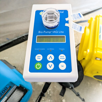 Indoor Air Quality (IAQ) testing during post remediation verification (PRV). Tanjun Mold Inspections inspector performing air sampling inside containment.